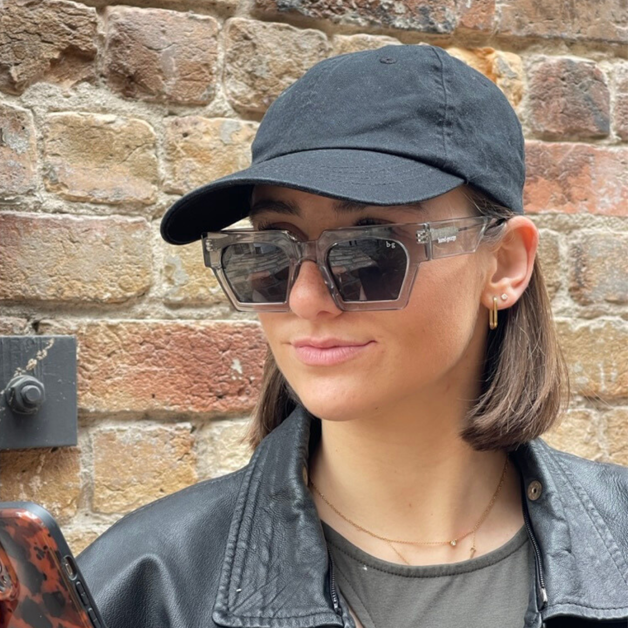 Woman in cap wearing grey square polarised Bored George sunglasses