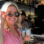 Fashion designer Caitlin Crisp in stylish cat eye sunglasses with green lenses and gold metal hardware