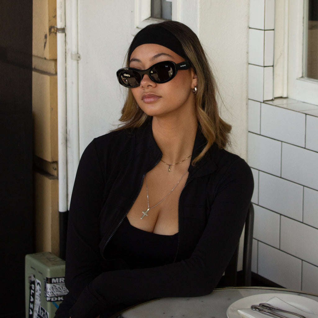 Close up of woman in activewear wearing black oval polarised Bored George sunglasses